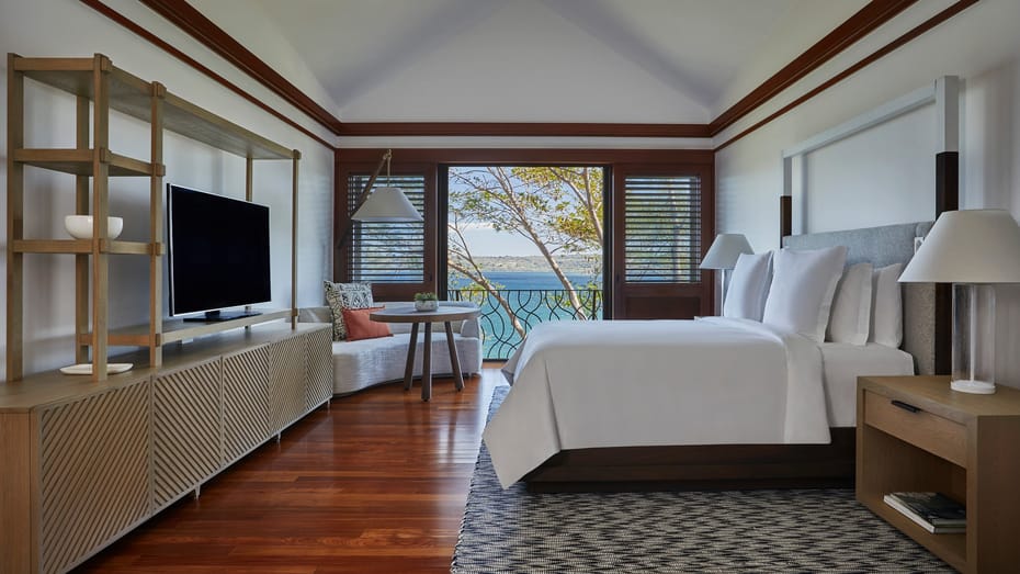 Spacious one-bedroom suite with private plunge pool surrounded by lush jungle canopy, featuring modern furniture and ocean views