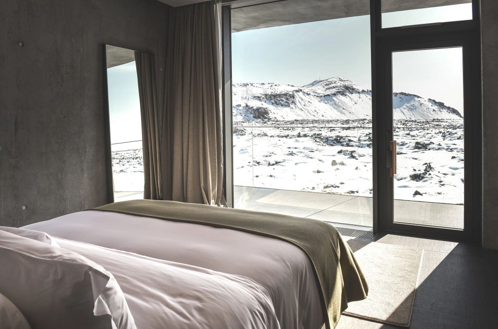 Luxurious scenset retreat nestled in rugged Icelandic landscape, featuring sleek modern architecture with floor-to-ceiling windows overlooking dramatic volcanic terrain