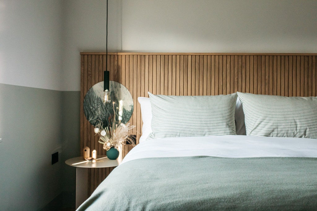 Elegant town hotel room with contemporary design, crisp white linens, modern furnishings, large window overlooking urban streetscape in United Kingdom