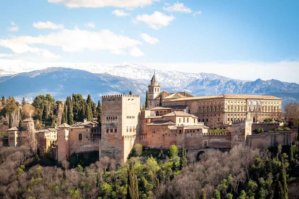 Ornate Moorish architecture of Alhambra's palace gardens, golden sunlight filtering through intricate Islamic geometric patterns and lush Granada landscape