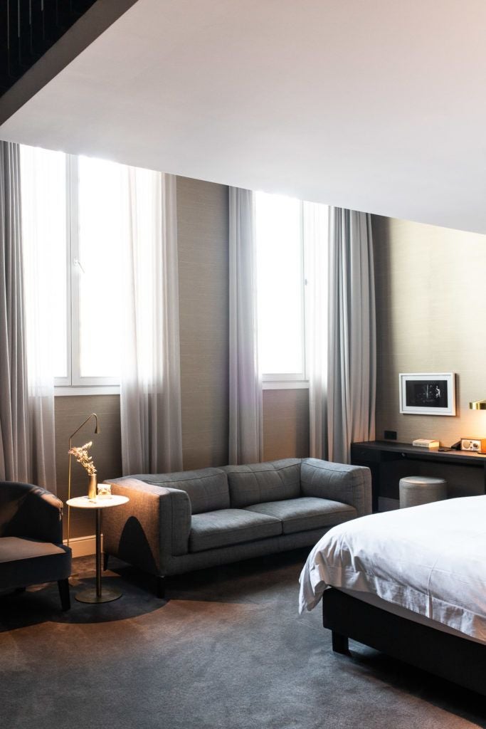 Elegantly styled luxury hotel room with plush white bedding, sophisticated decor, and warm lighting at Pillows Grand Boutique Hotel Reylof in Belgium