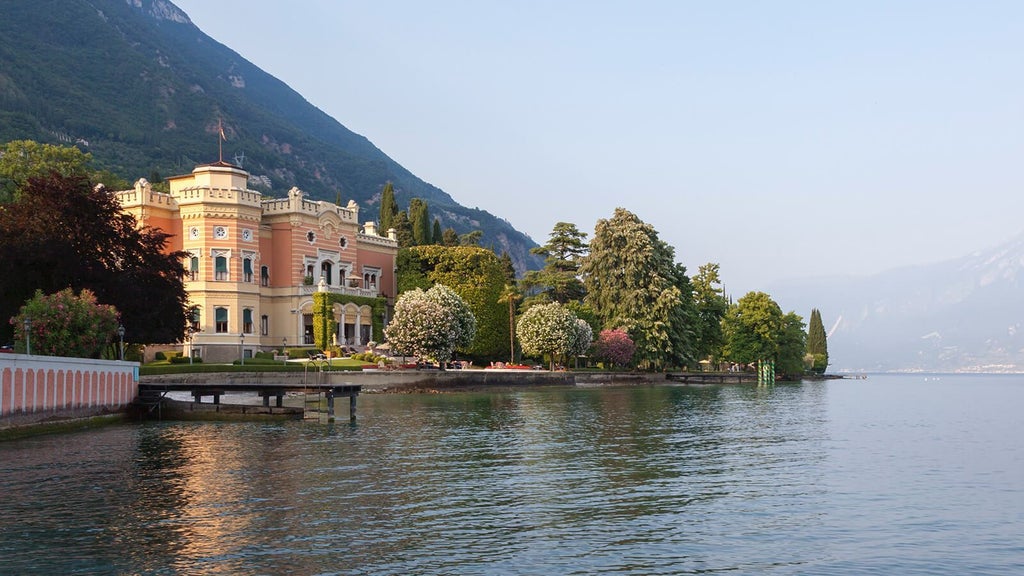 Elegant Italian hotel nestled in rolling hills, featuring stone archways, terra cotta roof tiles, and manicured gardens with cypress trees