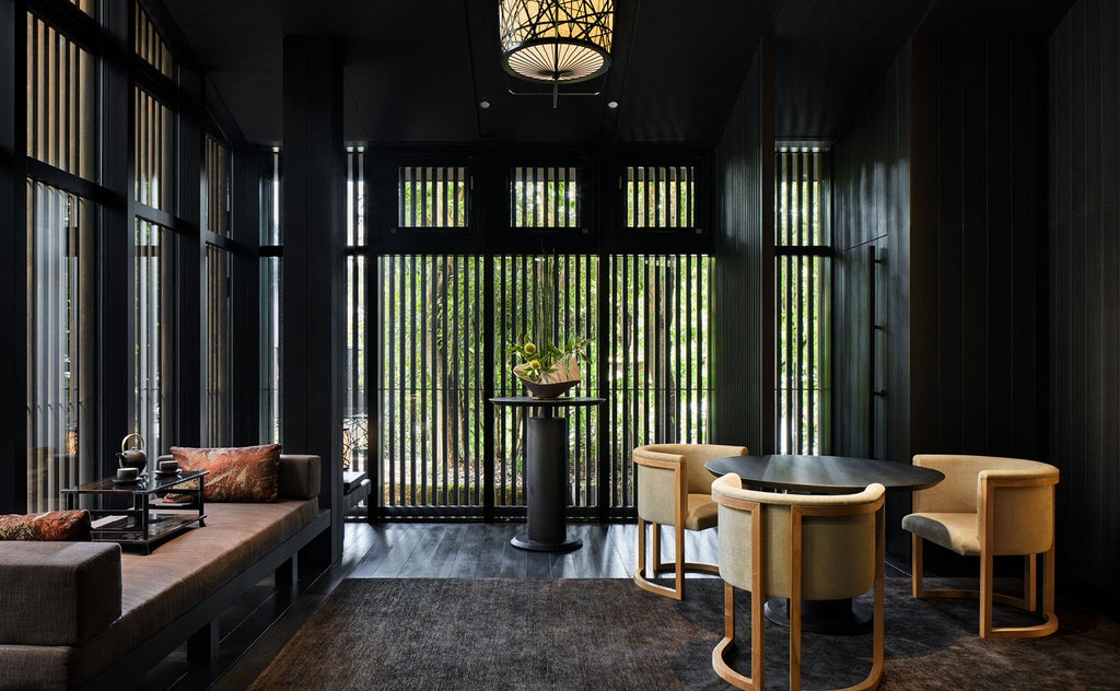 Traditional Japanese pavilion at Aman Kyoto nestled among lush maples, featuring wooden architecture and serene rock garden illumination