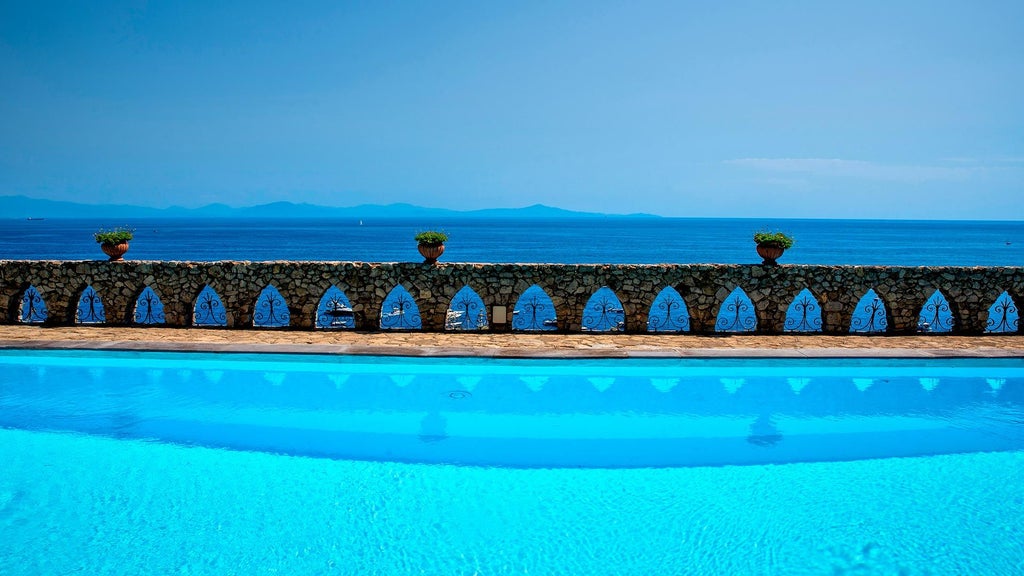 Five-star cliffside hotel in Amalfi with modern white architecture, infinity pool overlooking Mediterranean Sea and dramatic coastal views