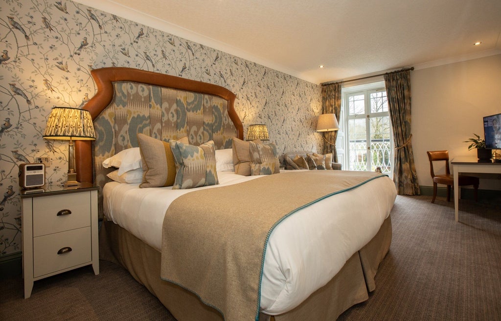 Elegant superior hotel room at Rothay Manor with plush bedding, sophisticated decor, and soft neutral tones overlooking scenic countryside views