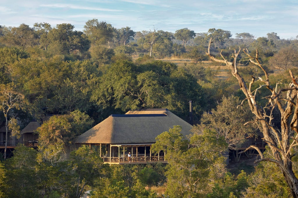 Elegant safari lodge suite with private deck overlooking African bush, featuring plush seating and canvas walls at Londolozi Founders Camp