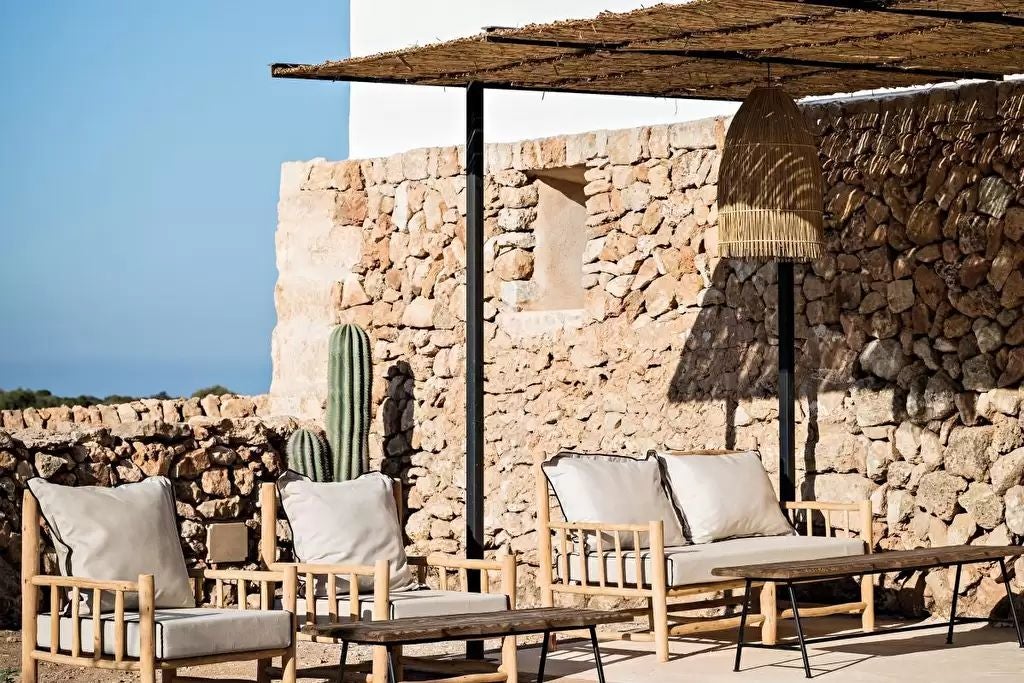 Historic stone tower hotel with Mediterranean terracotta rooftops, azure coastline, and lush green gardens in coastal Spain, showcasing elegant architecture and scenic luxurious surroundings