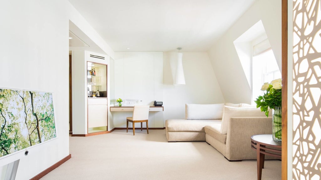 Luxurious COMO Suite with plush king bed, modern minimalist decor, soft neutral tones, floor-to-ceiling windows overlooking London cityscape