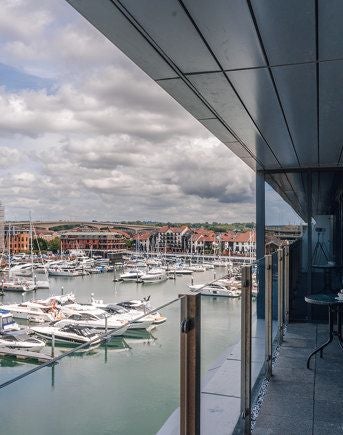 Spacious deluxe marina view suite with private balcony, contemporary furnishings, and sweeping waterfront scenery at Harbour Hotel Southampton, UK