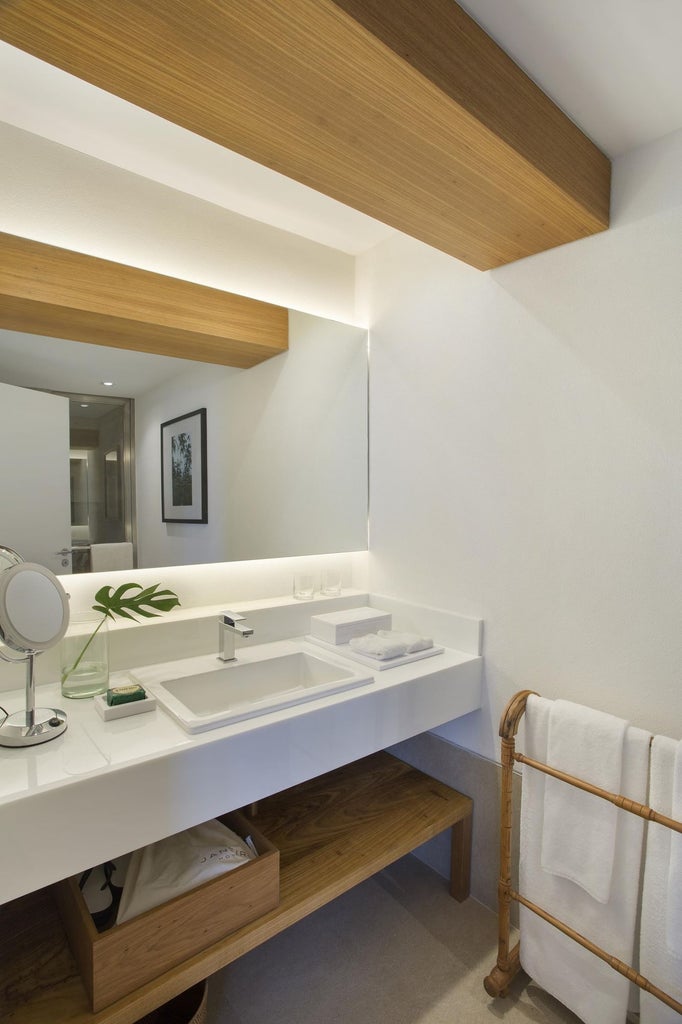 Sleek contemporary hotel room with panoramic city views, minimalist design, large windows, and elegant Brazilian-inspired neutral color palette in Janeiro Hotel