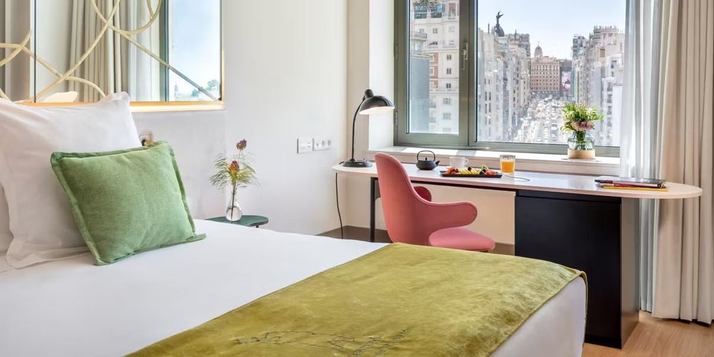 Luxurious modern suite overlooking Madrid's skyline, featuring sleek contemporary design, floor-to-ceiling windows, and panoramic urban landscape views