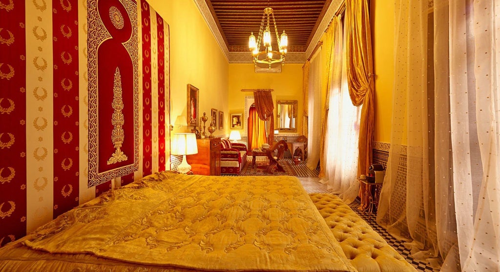 Elegant Moroccan riad-style deluxe superior room with intricate tile work, traditional archways, plush bedding, and rich cultural design elements