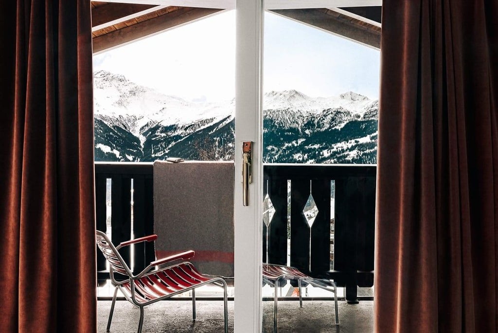 Luxurious Swiss chalet suite with panoramic alpine views, featuring modern minimalist design, elegant wood paneling, and floor-to-ceiling windows overlooking snow-capped mountains.