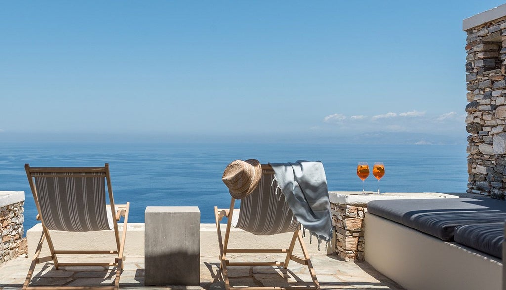 Elegant whitewashed Cycladic hotel room with minimalist design, crisp white linens, blue accents, and panoramic Aegean Sea view from Verina Astra in Sifnos, Greece