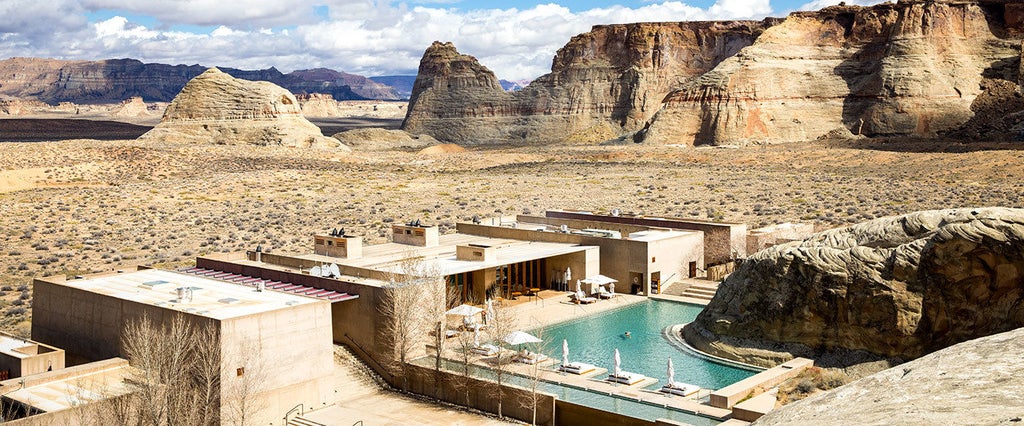 Minimalist luxury desert resort Amangiri nestled in Utah canyon, featuring geometric concrete architecture and infinity pool at sunset