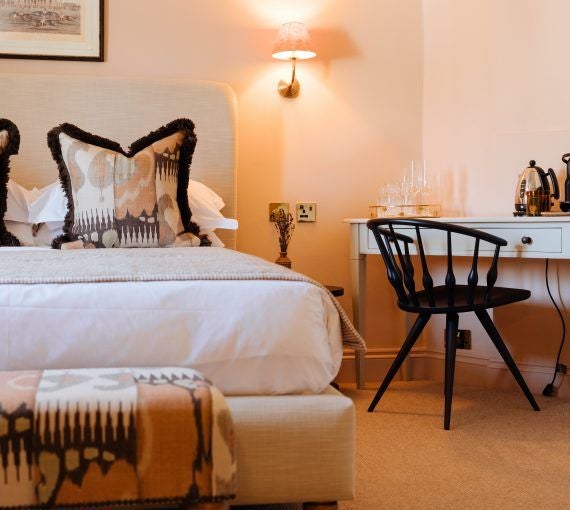 Elegant deluxe king room at The Yard in Bath, featuring plush bedding, sophisticated neutral decor, and warm ambient lighting in a refined UK boutique hotel setting.