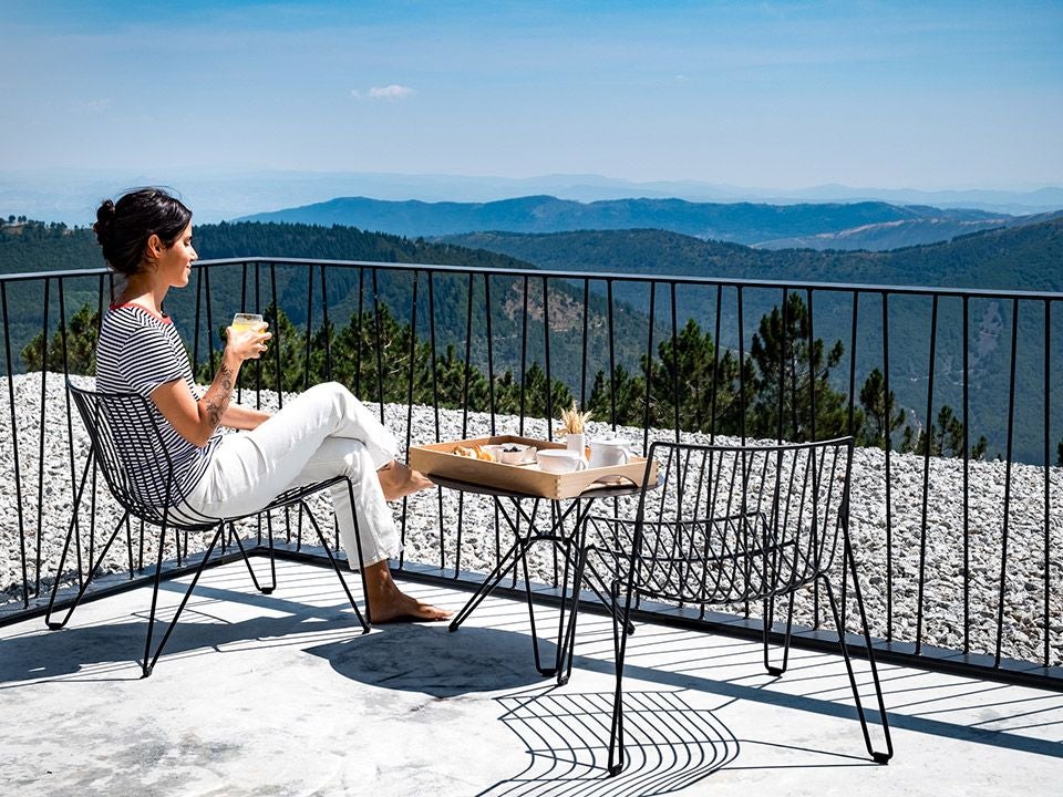 Luxurious mountain-view hotel in Portugal's Serra da Estrela, featuring elegant architecture with stone walls and panoramic alpine landscape