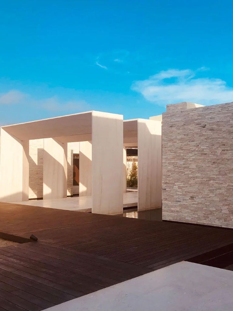 Modern luxury beachfront hotel with infinity pools overlooking Pacific Ocean, minimalist Japanese-inspired architecture in desert setting