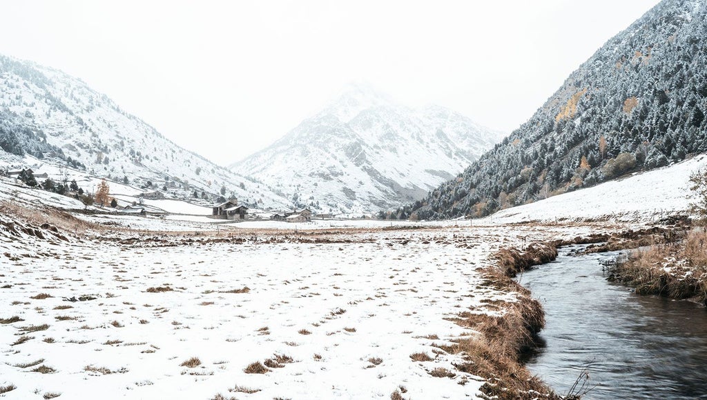 Luxurious mountain lodge nestled in scenic Andorran landscape, rustic wooden exterior with snow-capped peaks, warm alpine ambiance and elegant architectural design