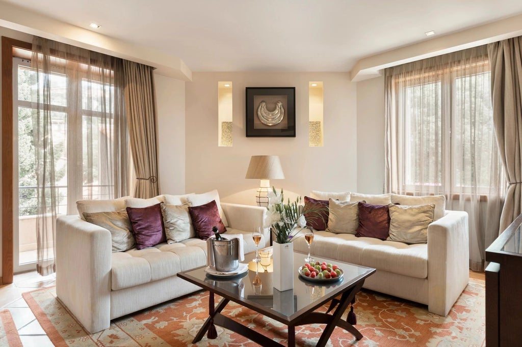 Elegant junior suite with garden view at Tiara Yaktsa, featuring plush white bedding, modern decor, and soft natural lighting through large windows