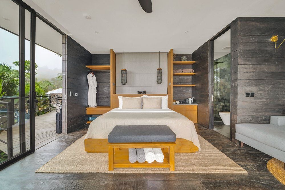 Luxurious wooden studio cabin in Munduk with floor-to-ceiling windows, private balcony, and panoramic mountain views across Bali's jungle