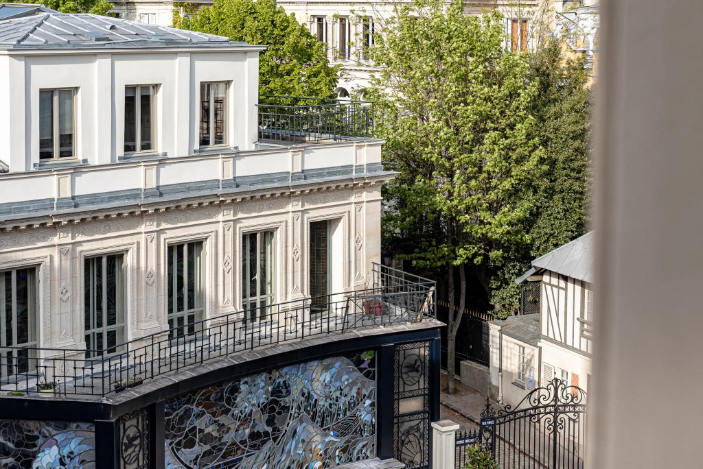 Luxurious boutique hotel in Paris with elegant pink facade, vintage French architecture, and chic Parisian street scene in the trendy Pigalle neighborhood