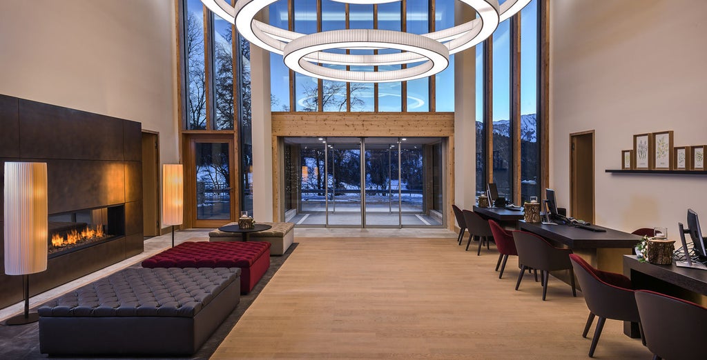 Luxurious mountain resort with glass facade nestled in Swiss Alps, featuring modern architecture and panoramic lake views