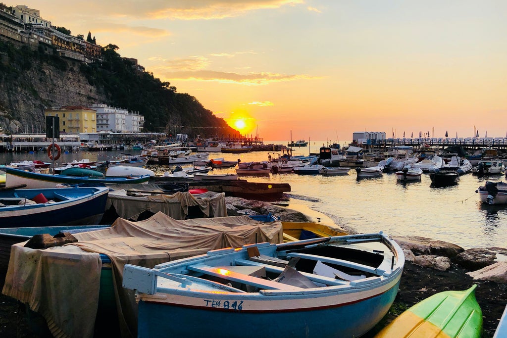 Sun-drenched cliffside town of Positano along Amalfi Coast, with pastel-colored villas cascading down to turquoise Mediterranean waters