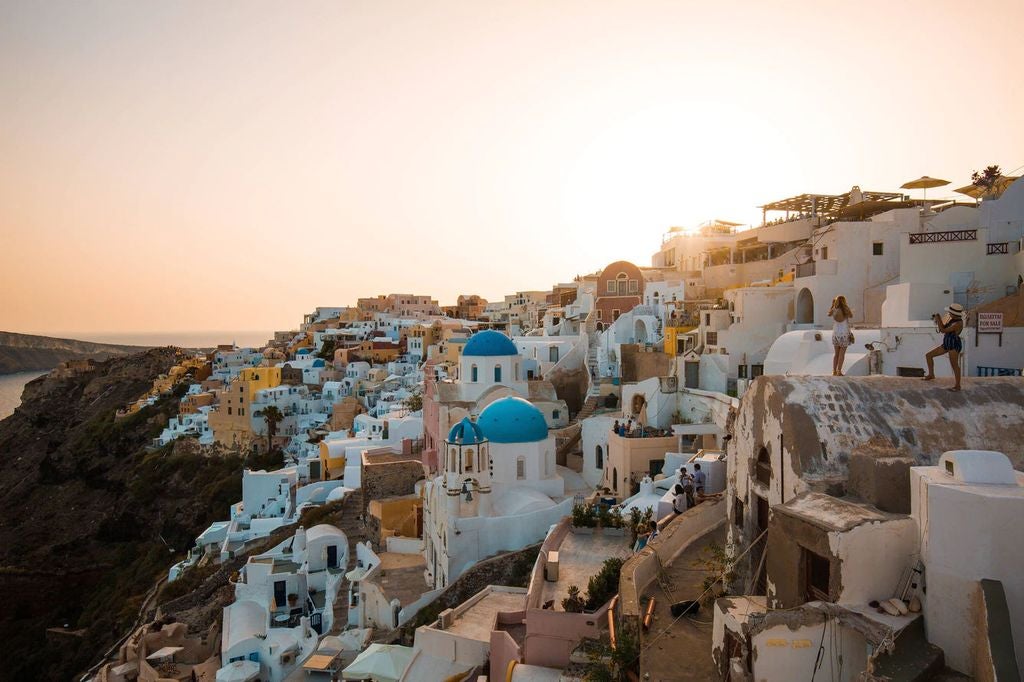 Whitewashed luxury suites cascade down Santorini's cliffs, featuring private infinity pools overlooking the Aegean Sea's deep blue waters