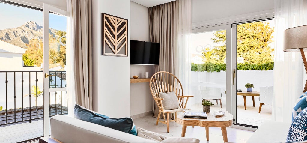 Luxurious Nobu Hotel Marbella Junior Suite with modern white decor, plush king bed, panoramic windows, and elegant contemporary Spanish coastal design