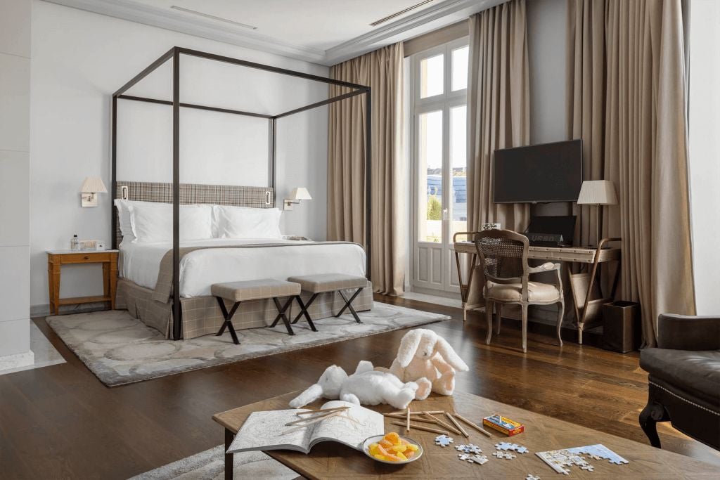 Luxurious family suite at URSO Hotel & Spa in Spain, featuring elegant decor, spacious layout, modern furnishings, and large windows with soft natural light