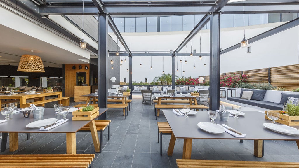 Modern coastal hotel with minimalist white architecture, sun-drenched terrace, and infinity pool overlooking the Atlantic Ocean in Portugal