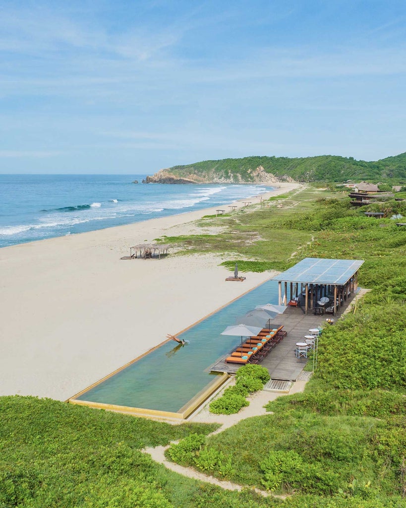 Luxurious boutique hotel nestled on a secluded Mexican coastline, featuring minimalist architecture, infinity pool, and panoramic ocean views at sunset