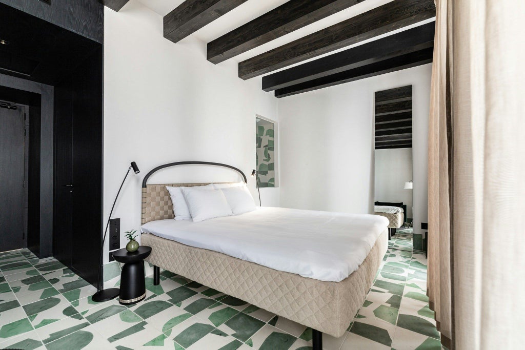 Elegant deluxe hotel room at Concepció by Nobis in Spain, featuring minimalist design with warm wood tones and sleek contemporary furnishings.