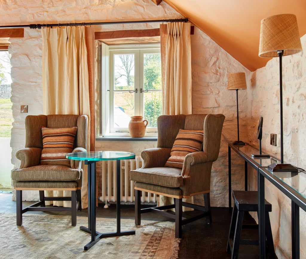 Luxurious rustic-chic bedroom with plush white bedding, exposed wooden beams, and soft natural light in the Grove of Narberth's Byre accommodation.