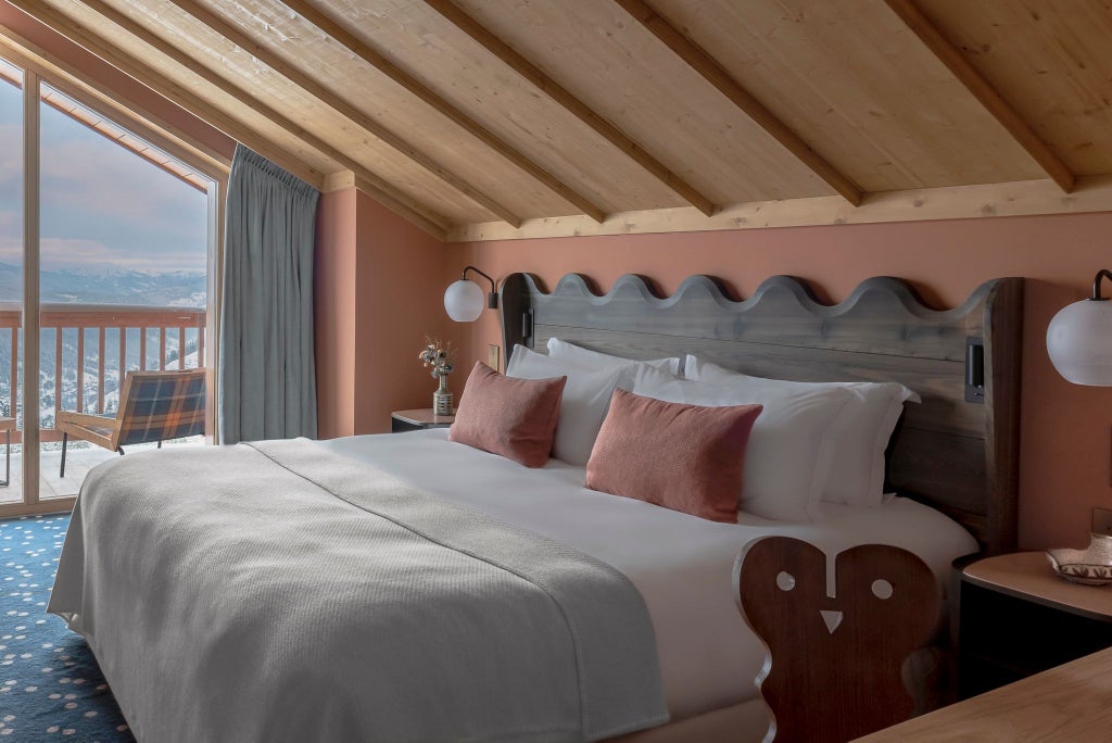 Luxurious two-room Deluxe Suite at Le Coucou Méribel, featuring elegant alpine-inspired decor with warm wood tones and contemporary mountain chalet design.