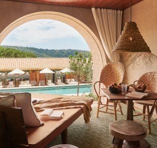 Infinity pool overlooking Mediterranean Sea at luxury St Tropez hillside hotel, with sunbeds and panoramic coastal views at sunset