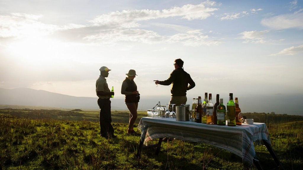 Luxurious safari camp nestled on Ngorongoro Crater's rim, blending modern design with panoramic Tanzania wilderness views at golden hour.