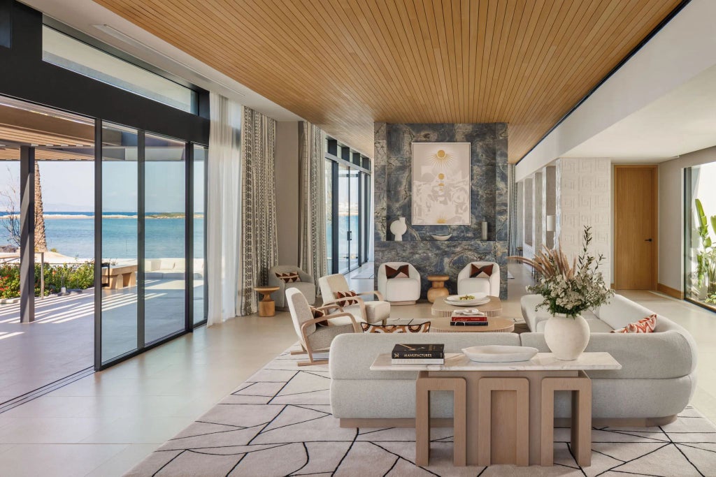 Luxurious three-bedroom seafront suite at One&Only Aesthesis, featuring elegant modern design with panoramic Grecian coastline views and pristine interiors