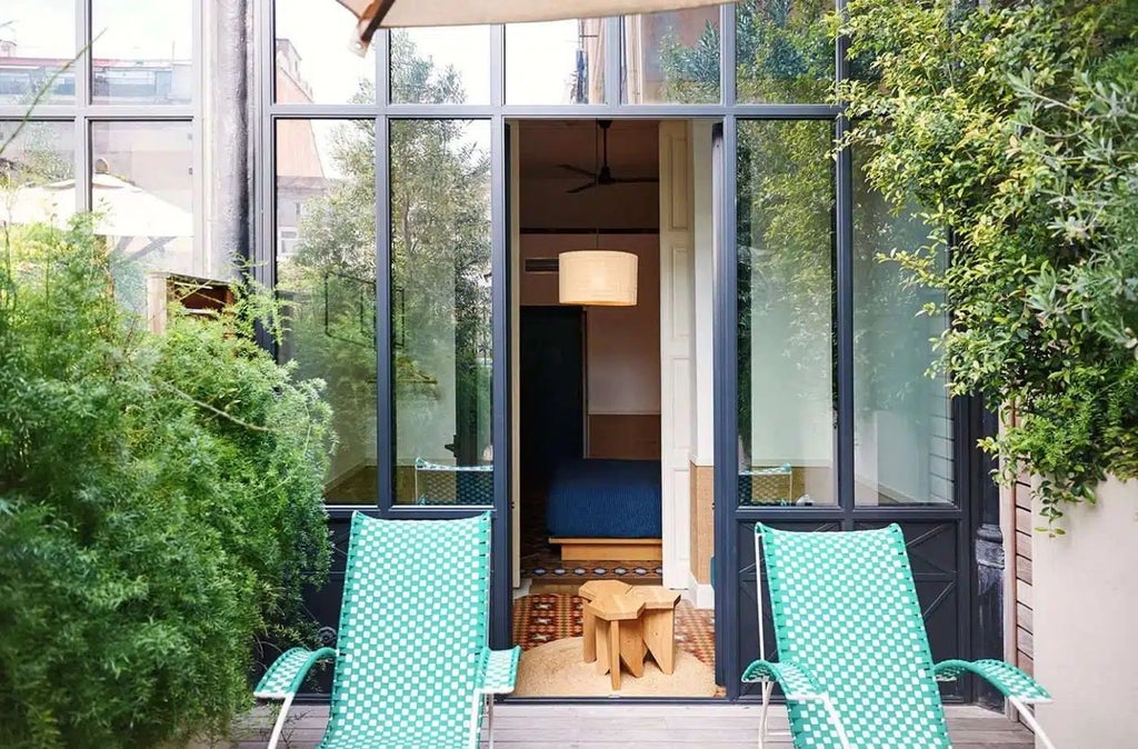 Sunlit Spanish courtyard at Casa Bonay with lush greenery, elegant outdoor furniture, and warm terracotta tones reflecting Barcelona's architectural charm