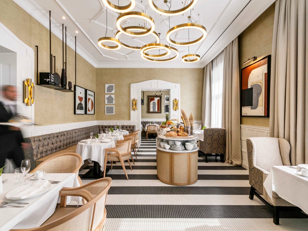 Elegant marble lobby of Fermai Hotel with crystal chandeliers, ornate columns, plush seating areas and gold-framed artwork