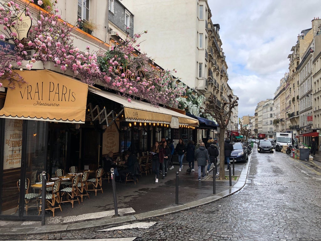 Charming cobblestone streets of Montmartre, Paris, with elegant Parisian architecture, artists painting, and the iconic Sacré-Cœur Basilica in the background under soft golden light