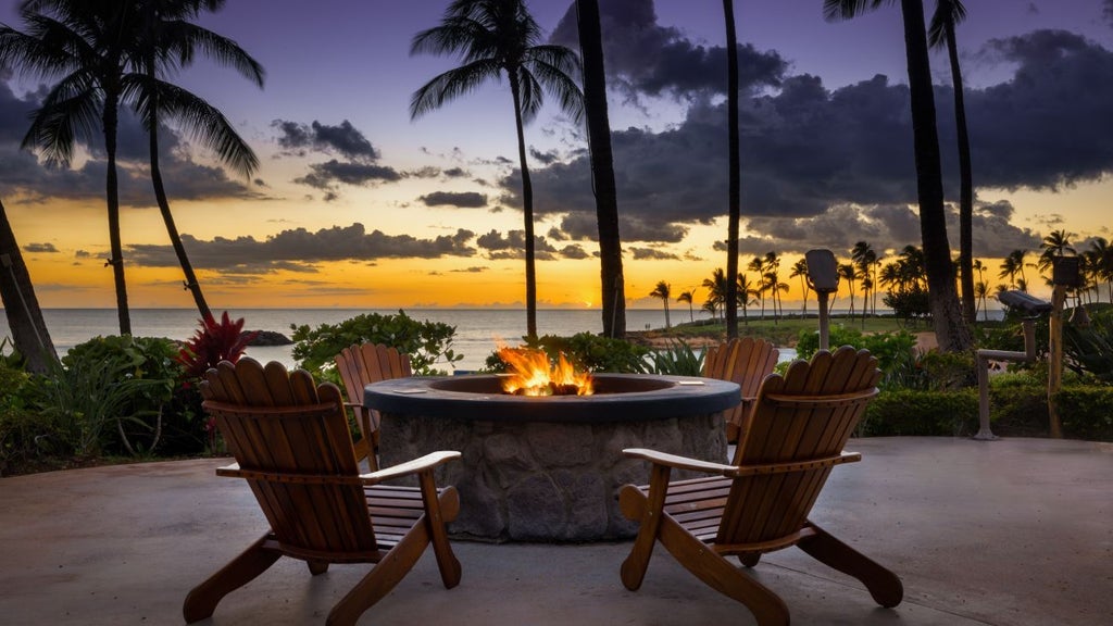 Luxury beachfront resort with turquoise waters, pristine white sand, palm trees, and modern Hawaiian-style architecture at tropical Ko Olina coastline