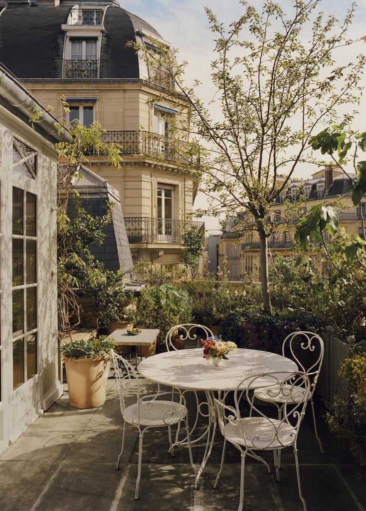 Elegant, cream-colored Art Deco facade of Château Voltaire hotel in Paris, featuring ornate windows and refined architectural details at dusk