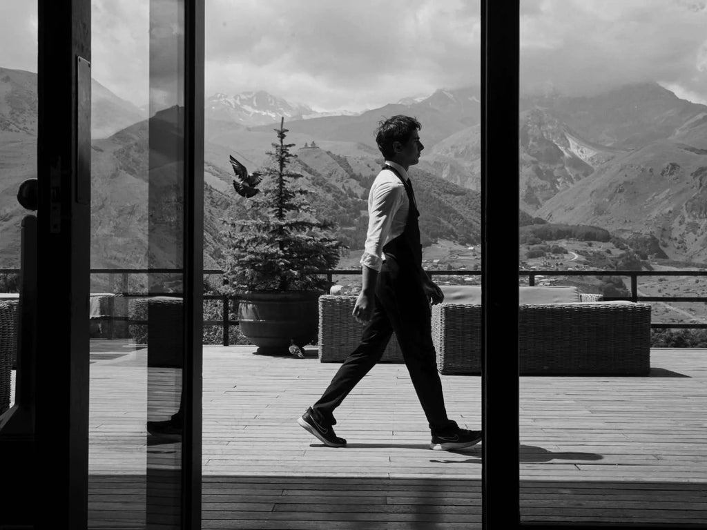 Panoramic mountain view of luxurious alpine hotel with modern design, featuring expansive windows and contemporary architecture against rugged Georgian landscape