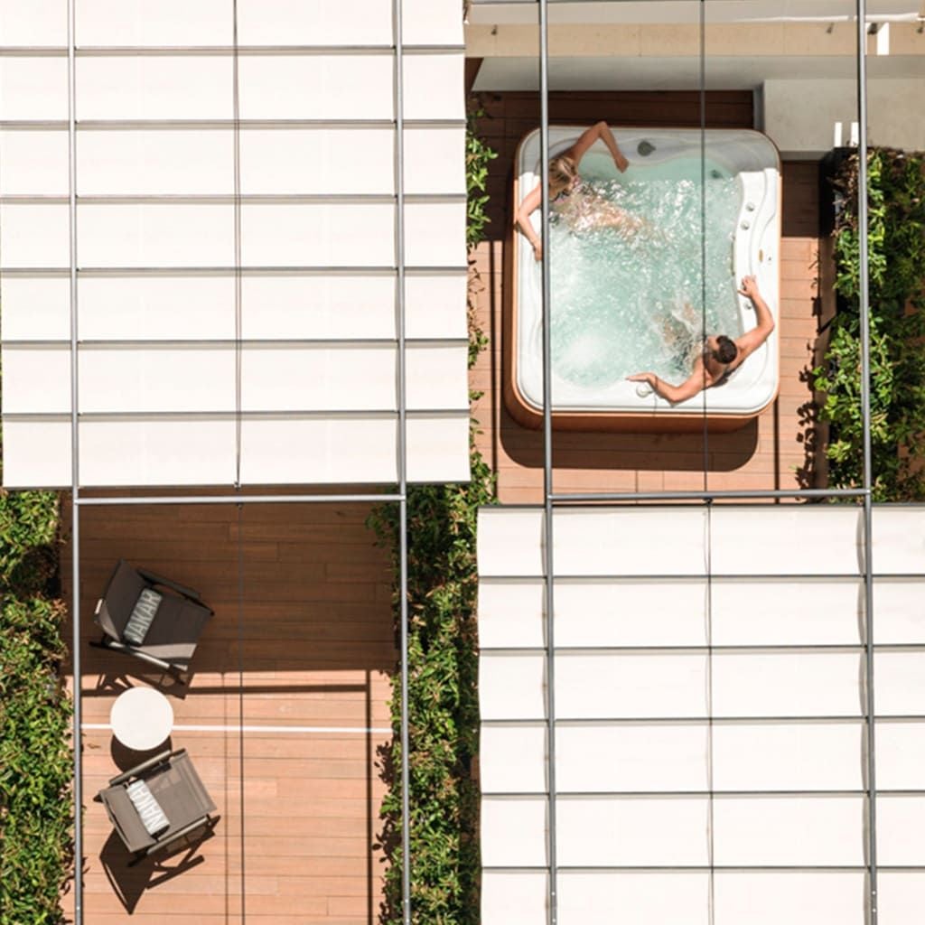 Luxurious rooftop terrace of a sleek modern hotel in Palma de Mallorca, with a sparkling blue pool overlooking the historic city skyline at sunset.