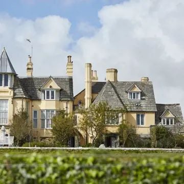 Luxurious countryside hotel nestled in lush Devon landscape, featuring rustic stone building, manicured gardens, and elegant architectural details of The Pig at Combe