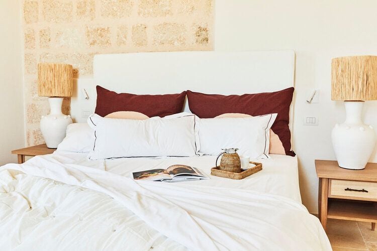 Luxurious stone tower suite at Masseria Calderisi, featuring rustic Italian elegance with antique furnishings and panoramic countryside views in Puglia.