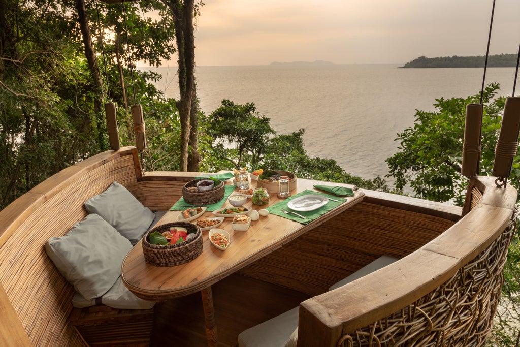 Luxurious beachfront villa at Soneva Kiri with private infinity pool, natural wood architecture, and lush tropical jungle backdrop at sunset