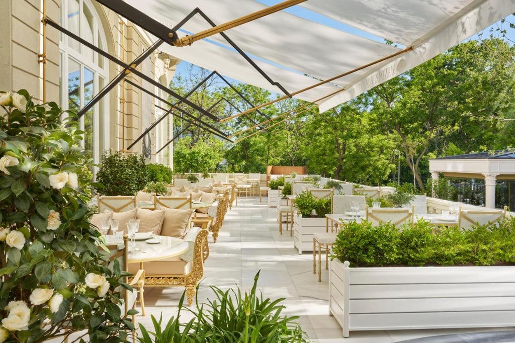 Historic Mandarin Oriental Ritz Madrid's grand facade with ornate Belle Époque architecture, elegant balconies and gilded details at dusk